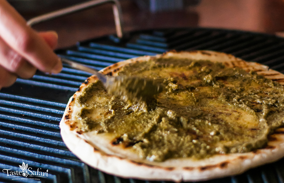 Pizza base spread with pesto and topped with salami and bocconcini