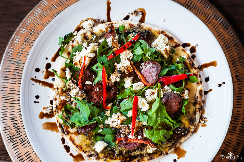 Salami, rucola and feta appetizer pizza on a plate